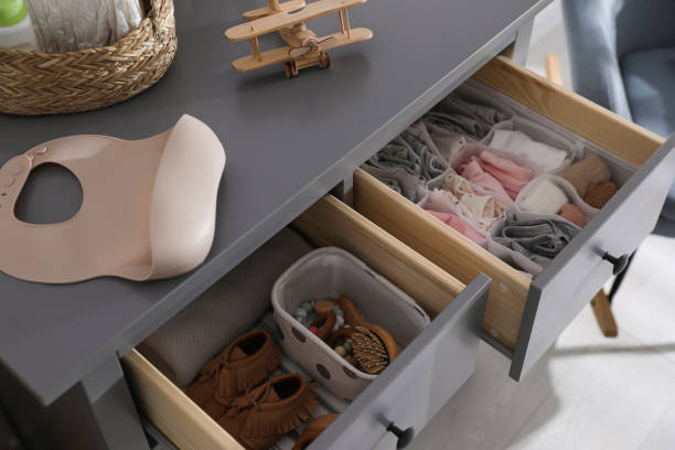 istock Open cabinet drawers with clothes and different items in child room 1349373557