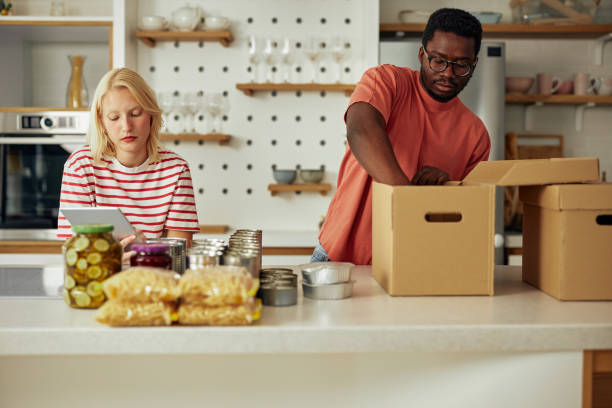 istock Couple using digital tablet and sorting food for donation 1349374776
