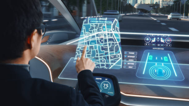 istock Futuristic Concept: Stylish Businessman Setting Location on an Interactive Navigation App on an Augmented Reality Dashboard while Sitting in an Autonomous Self-Driving Zero-Emissions Electric Car. 1349375109