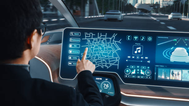 istock Futuristic Concept: Stylish Businessman Setting Location on an Interactive Navigation App on an Augmented Reality Dashboard while Sitting in an Autonomous Self-Driving Zero-Emissions Electric Car. 1349375176
