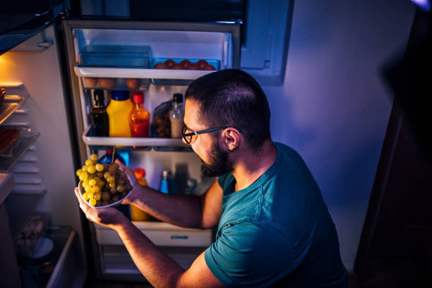 istock Man taking a grapes out of the fridge 1349376855