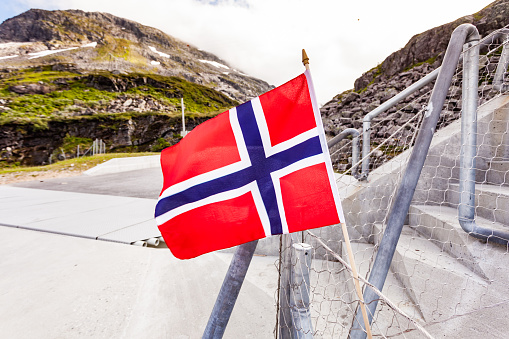 Norwegian flag with a Dramatic aerial view of lake town and fjords in background. Top of Fjords in Southern Norway - European Hiking and travel Concept