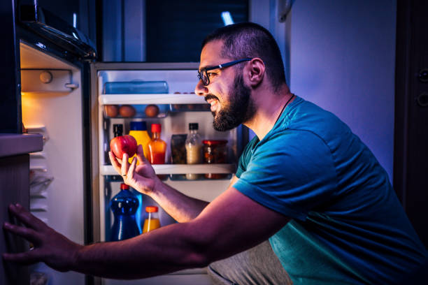 istock Man taking apple out of the fridge 1349380085