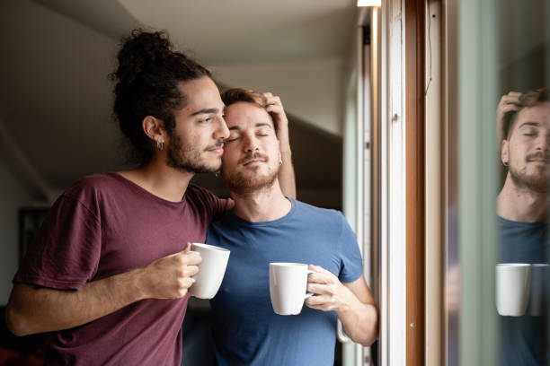 гей-пара делится особым моментом утром, гомосексуальная нежность, гей-пара любит домашнюю концепцию - coffee couple italy drinking стоковые фото и изображения