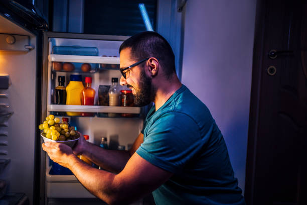 Man taking a grapes out of the fridge