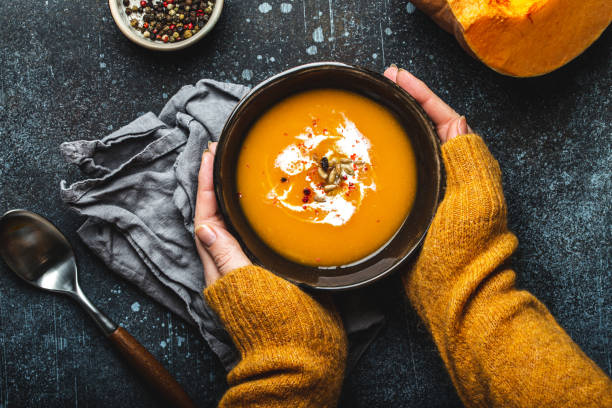 istock Female hands with bowl of pumpkin soup 1349382000