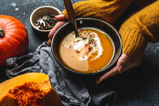 istock Female hands with bowl of pumpkin soup 1349382012
