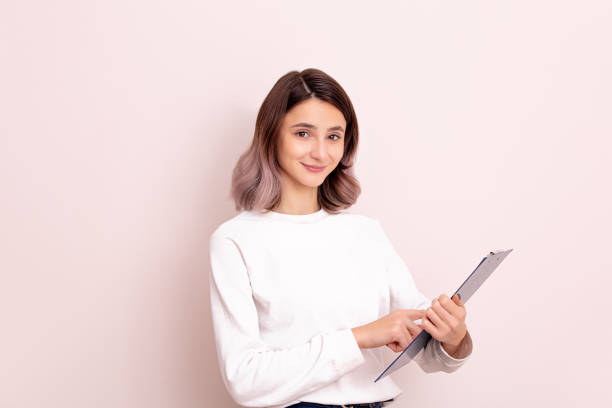 Portrait of a young girl model beautiful and natural with a tablet in her hands in the studio Portrait of a young girl model beautiful and natural with a tablet in her hands in the studio spokesmodel stock pictures, royalty-free photos & images