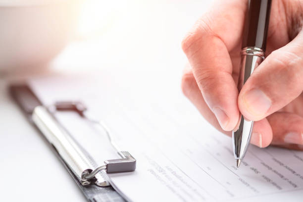 istock Image of Hand using writing pen with questionnaire or paperwork survey question filling 1349382831