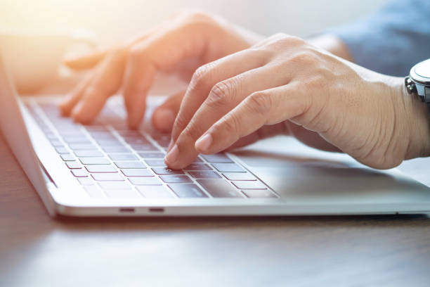 istock Close-up of man hands using and typing keyboard of laptop computer on office desk. 1349382877