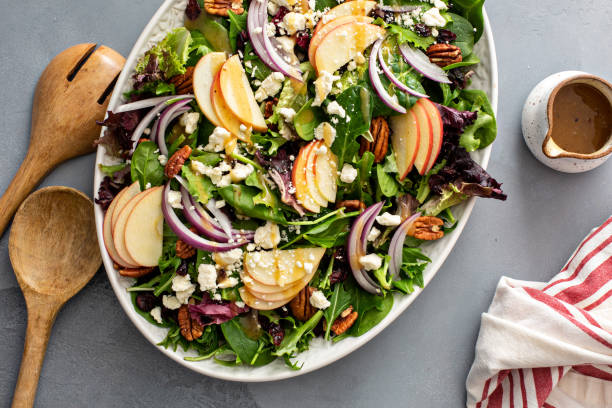 Winter salad with apple and pecans Winter salad with apple, red onion and pecans with vinaigrette dressing salad fruit lettuce spring stock pictures, royalty-free photos & images