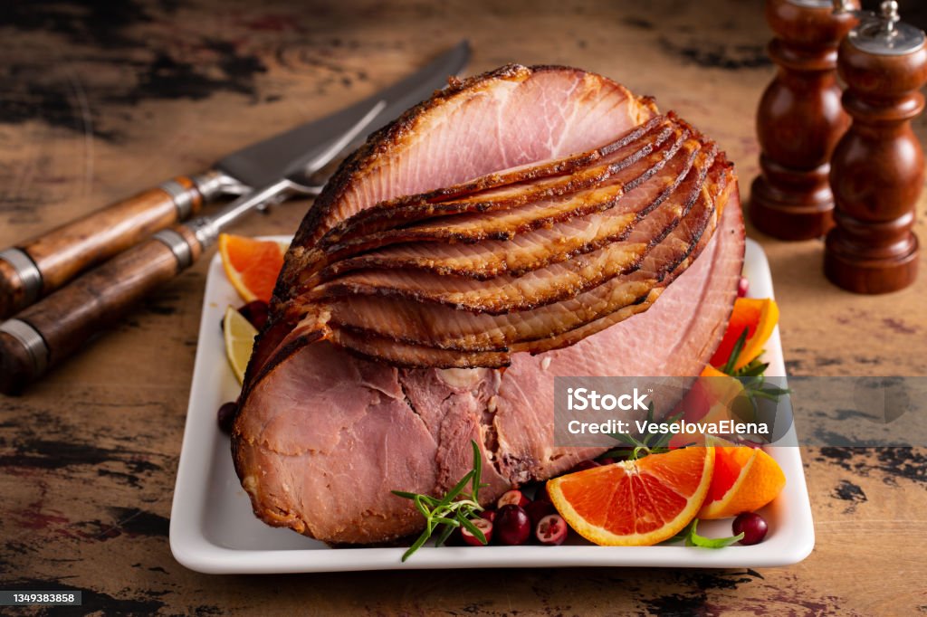Christmas or Easter spiral sliced ham Christmas or Easter spiral sliced ham with oranges and cranberries Ham Stock Photo