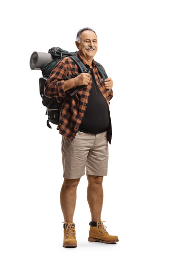 Full length portrait of a mature man with a backpack standing and smiling isolated on white background