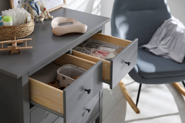 istock Open cabinet drawers with clothes and different items in child room 1349387499
