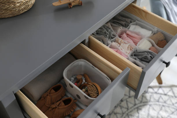 istock Open cabinet drawers with clothes and different items in child room 1349387572