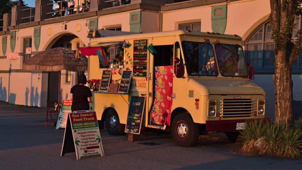 vista de san juan food truck vendiendo comidas orgánicas bolivan a peatones en english bay beach en west end, vancouver en el centro de la ciudad a la luz de la noche. - west end fotografías e imágenes de stock