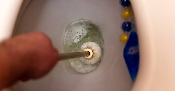 istock man washes a toilet bowl with a brush 1349388745