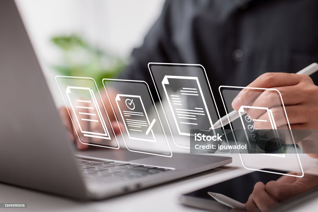 Paperless workplace idea, e-signing, electronic signature, document management. Businessman signs an electronic document on a digital document on a virtual notebook screen using a stylus pen. Document Stock Photo