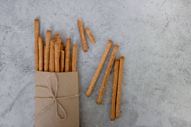 istock Bread sticks, with sesame seeds and whole grain flour on grey background. Top view, copy space. 1349390909