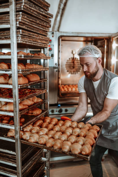 istock Male Baker Checking Condition Of Fresh Pastries In Oven 1349390932