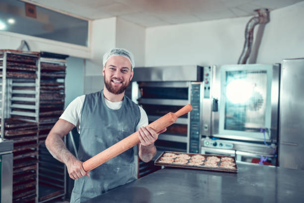 istock Happy Male Baker Showing His Favorite Rolling Pin 1349392268