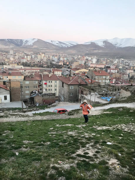 A school child walking at grass and behind Nigde city center Nigde, Turkey - February 17: A school child walking at grass and behind Nigde city center on February 17, 2019 in Nigde, Turkey. Nigde at Central Anatolia in Turkey. niğde city stock pictures, royalty-free photos & images