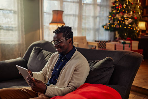 istock Smiling man enjoying with tablet on Christmas holiday 1349407176