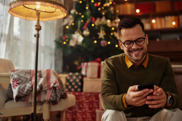 istock Man using a smartphone at home - Winter and Christmas Season 1349407186