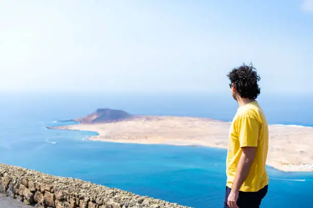 Photo of Man enjoying the views of the island of La Graciosa from Lanzarote.
