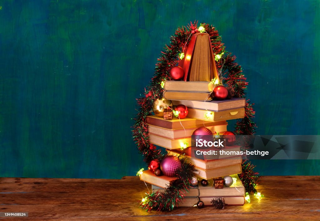 Giving books for christmas with stack of books forming a christmas tree.Reading,literature,education,gift,present,christian holiday concept Book Stock Photo