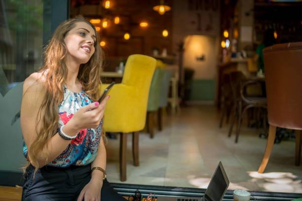 istock Businesswoman using laptop while enjoying work at cafe table with cup of coffee 1349408894