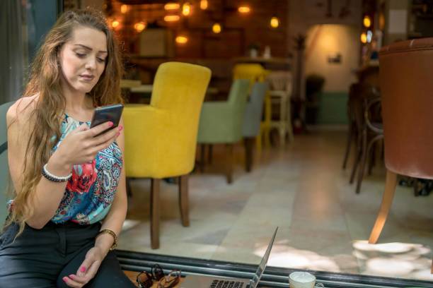 istock Businesswoman using laptop while enjoying work at cafe table with cup of coffee 1349408903