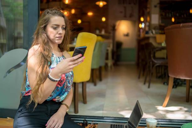 istock Businesswoman using laptop while enjoying work at cafe table with cup of coffee 1349409448