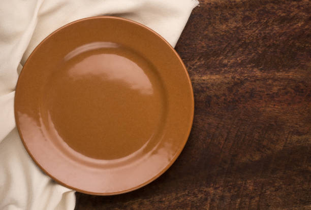 istock empty plate and a cloth napkin on a wooden background 1349410162