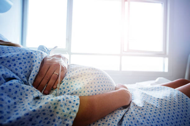 병원에서 임신 한 여성의 배의 클로즈업 - 임신 뉴스 사진 이미지