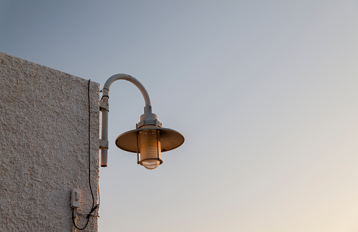 Street lamp on white wall against sky, in small fising town, Isleta del Moro, Gabo de Gata Nature Park, Almeria, Spain