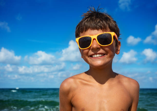 istock Smiling boy in sunglasses with sea on background 1349412010