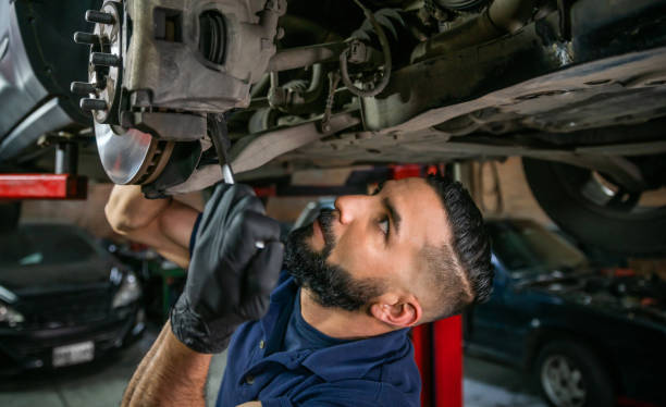istock Focused mechanic adjusting the car disk at a garage using a wrench 1349412627