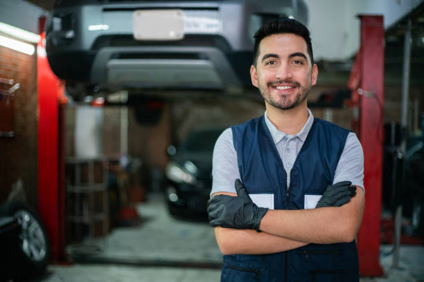 istock Happy technician working at a car workshop facing camera smiling with arms crossed 1349412684