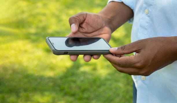 istock Hands of an African man using a touchscreen phone 1349414092
