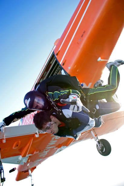 tandem de parachutisme pour le plaisir. sortie de l’avion pac - skydiving air aerial view vertical photos et images de collection