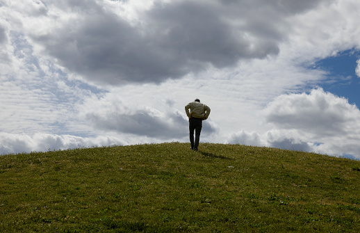 Portrait of Adult climbing up to top of hill on a cloudy day, in Madrid, Spain