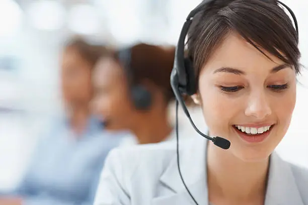 Photo of Smiling call center employee during a telephone conversation