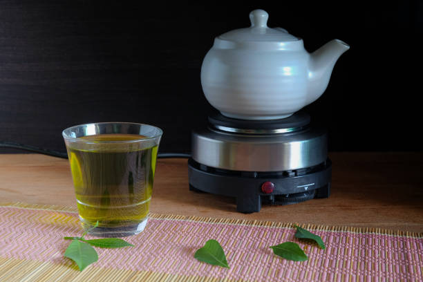 istock Fresh green tea with tea leaves and tea pot . 1349424835
