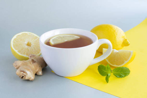 istock Tea with lemon and ginger in the white cup on the colored  background. Close-up. 1349425645
