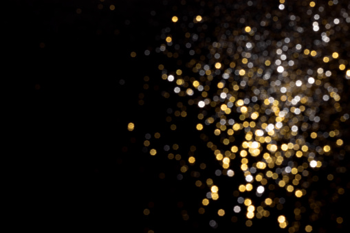 Golden and silver blurred bokeh lights on black background. Glitter sparkle stars for celebrate. Overlay for your design