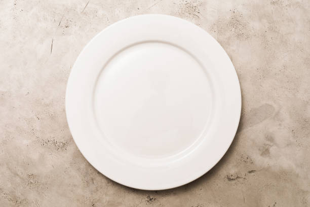 istock Empty white ceramic plate on light abstract background, top view, food background 1349427647