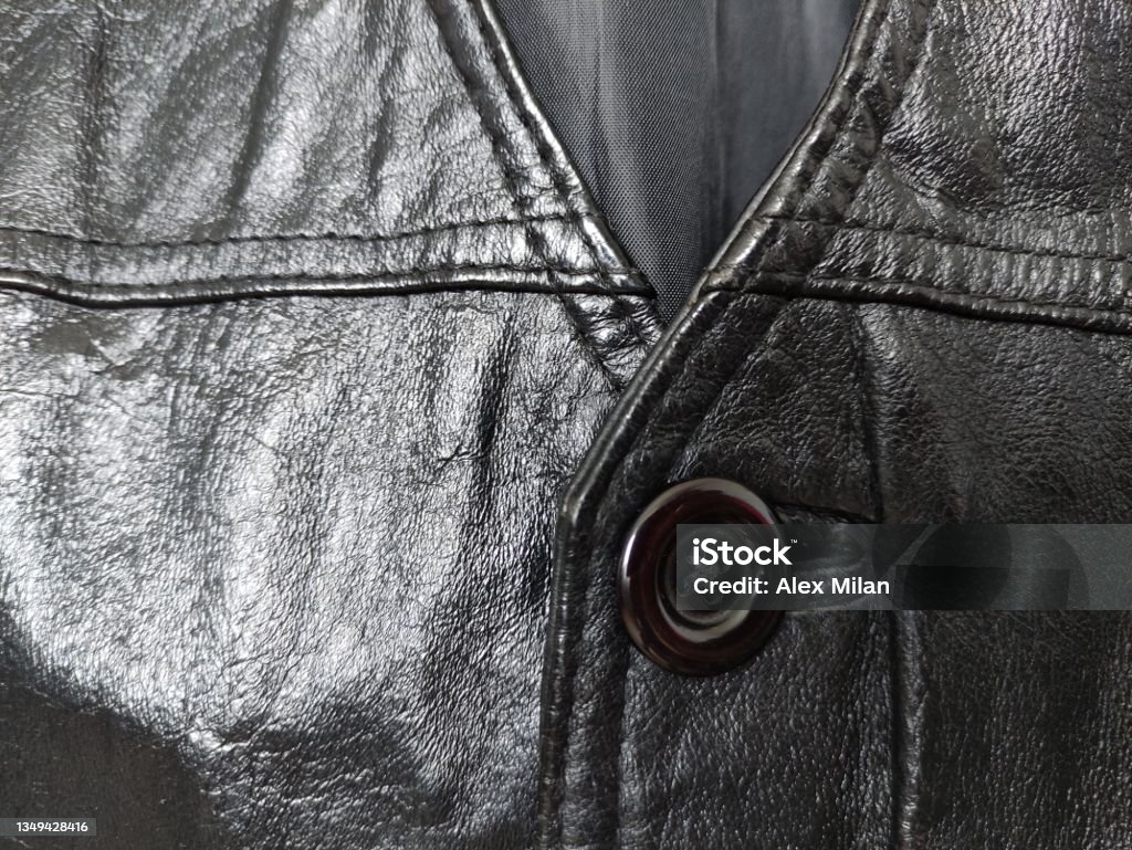 Plastic button on a leather vest Plastic button on the leather vest Beige Stock Photo