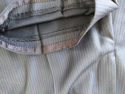 Stitch on the fabric with a sewing machine. Hemmed trousers, close-up