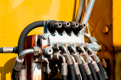 Close up of excavator hydraulic iron pipes.